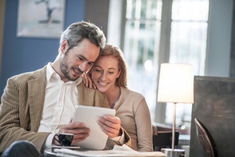 A couple looking at a touch-interface control panel for the automation system